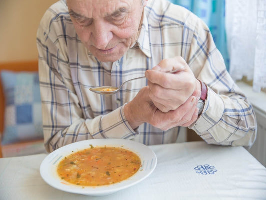elderly man with parkinson's disease having difficulty eating