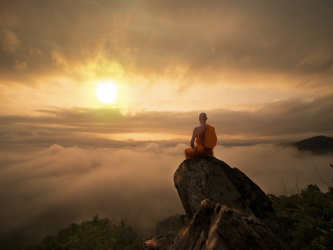 monk practicing deep breathing on a mountain