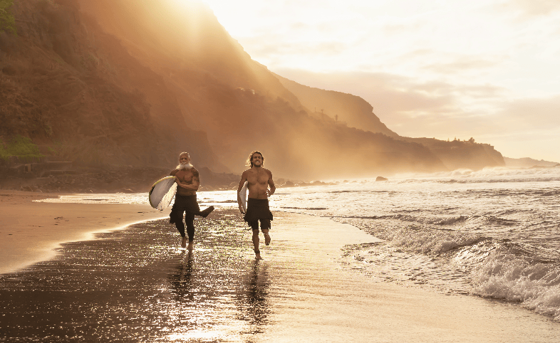 Surfers running on the beach in Southern California waves, with the brand Easy Day Hemp featured in the image. Easy Day Hemp offers a range of high-quality CBD products to help support a healthy and active lifestyle, including oils, softgels, gummies, and more.
