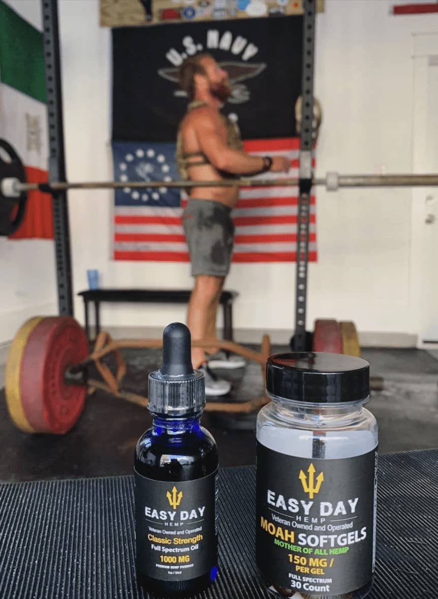 Eddie Gallagher, veteran Navy SEAL, working out in home gym with Easy Day Hemp full spectrum oil and MOAH gels in front