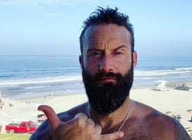Jason Higgins, CEO of Easy Day Hemp, making the Tuanis sign on a beach in Encinitas, California